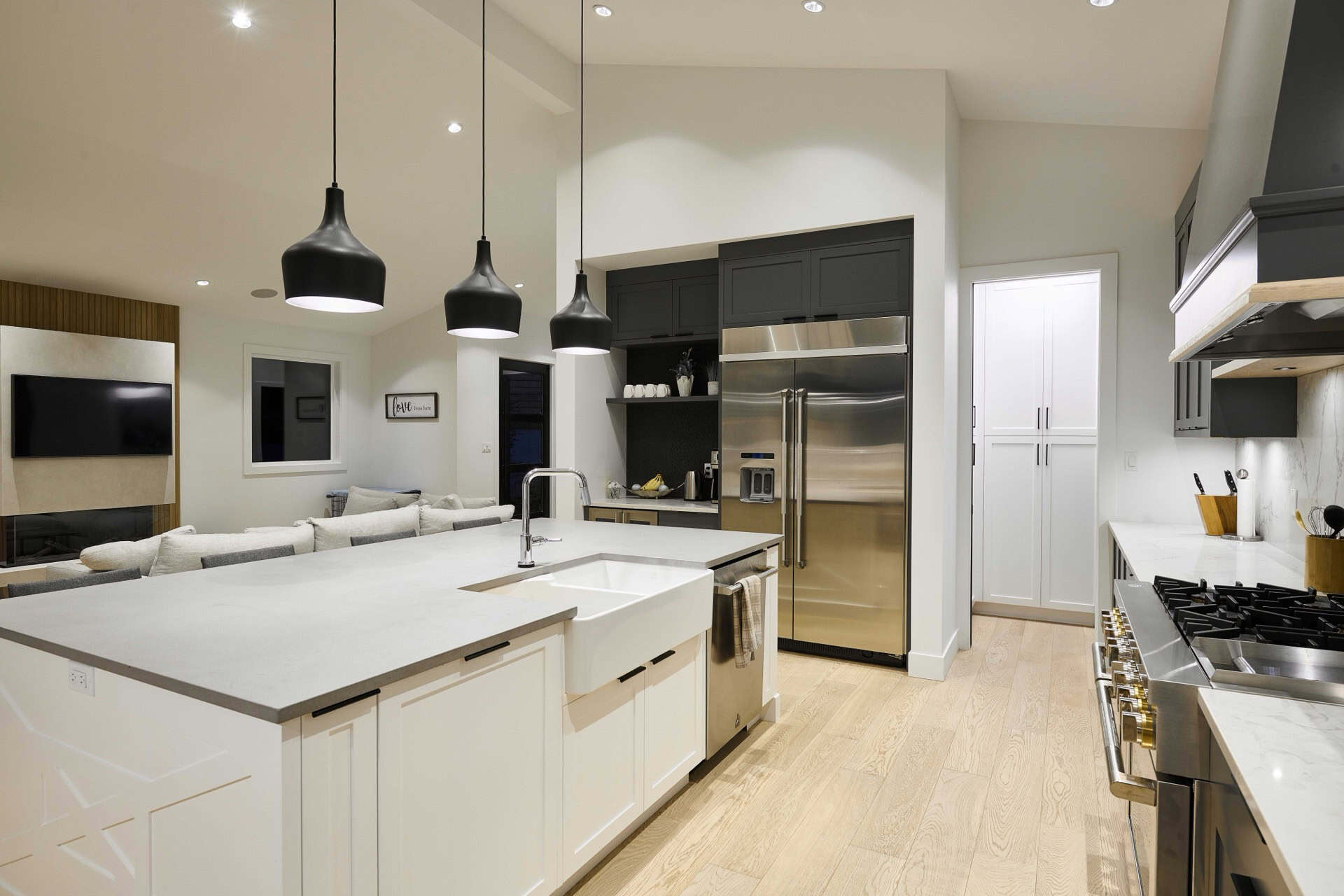 Modern open-concept kitchen with island and pendant lighting in a Whit Wof Homes design.