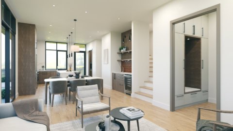 Interior view of a modern open-concept kitchen and living area with light wood floors and large cler.