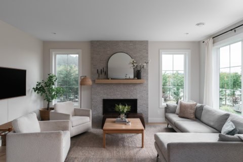 Bright living room with fireplace and large windows in a modern Victoria home.