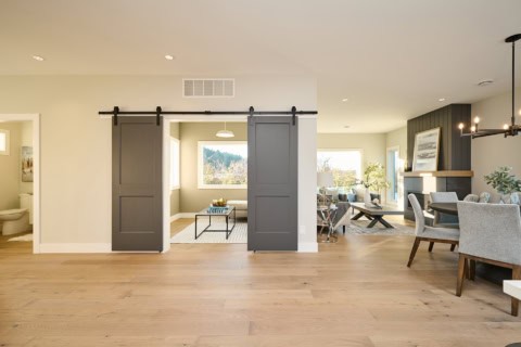 Open-concept living space with sliding barn doors and modern decor in Meadowview home by White Wolf;.