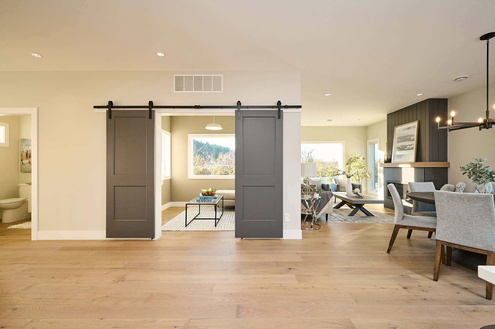 Open-concept living space with sliding barn doors and modern decor in Meadowview home by White Wolf;.