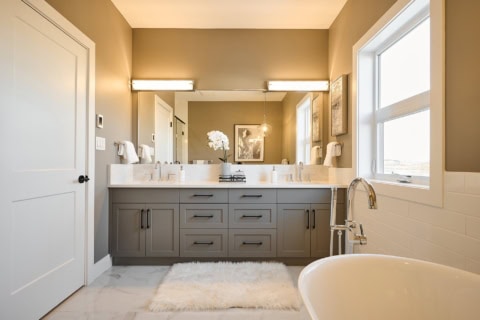 Modern ensuite bathroom with double vanity, gray cabinetry, and freestanding tub in Victoria BC home.
