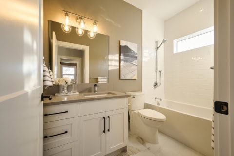 Modern bathroom at Meadowview: white vanity, tub/shower, and polished fixtures.