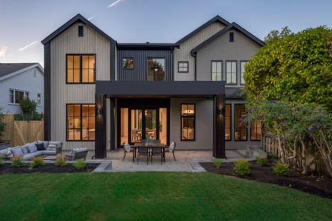 Victoria BC custom home by White Wolf Homes with modern grey siding, large windows, and inviting alf.