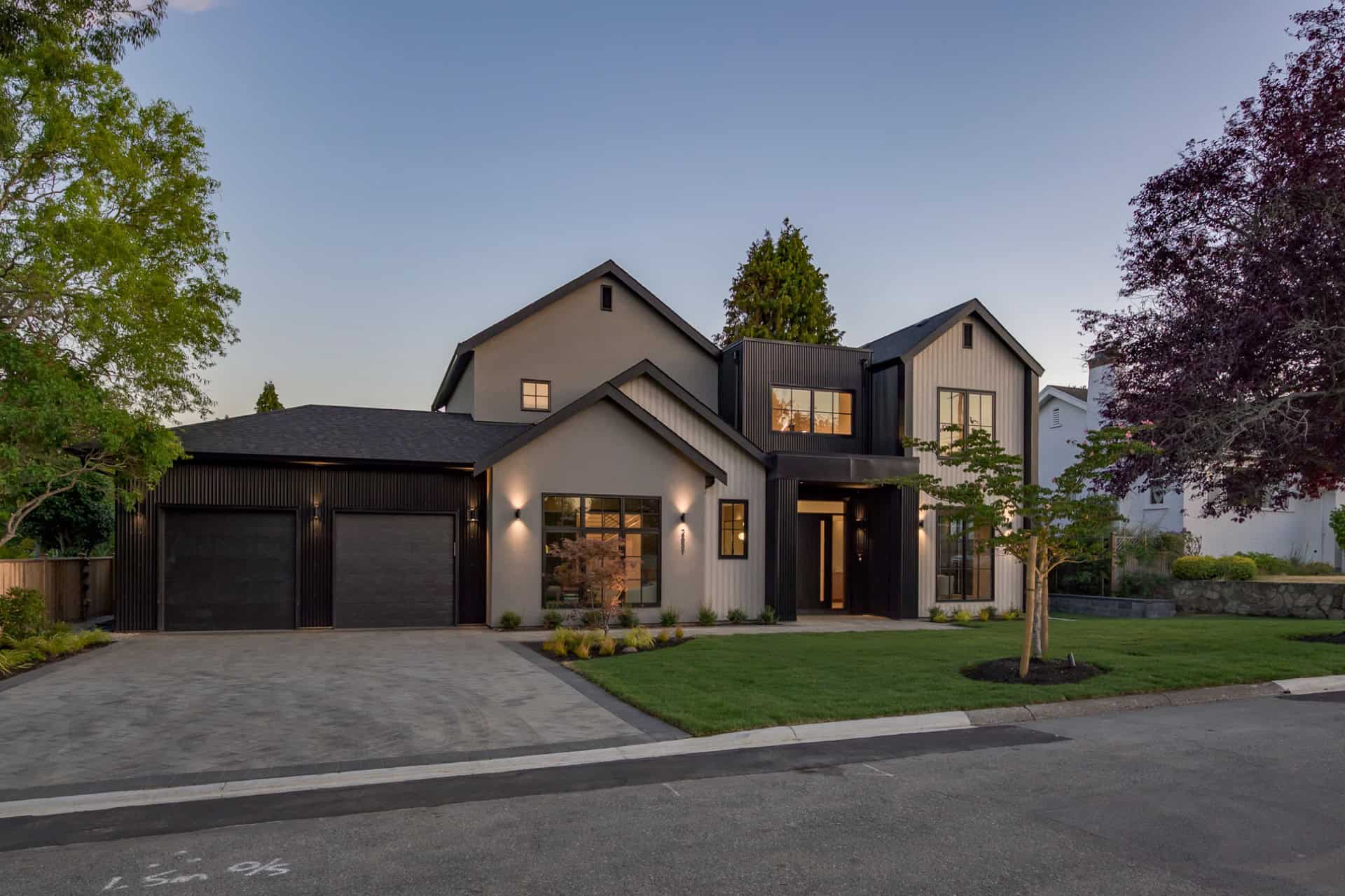 Modern two-story custom home in Victoria BC by White Wolf Homes with a three-car garage and manicued.