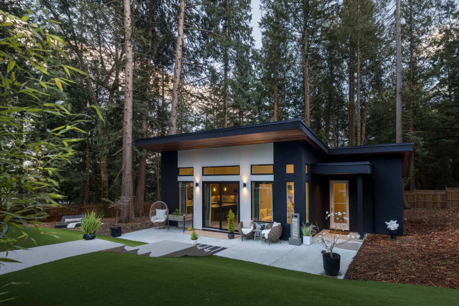 Modern Victoria BC home by White Wolf Homes with dark blue exterior and glass patio doors.