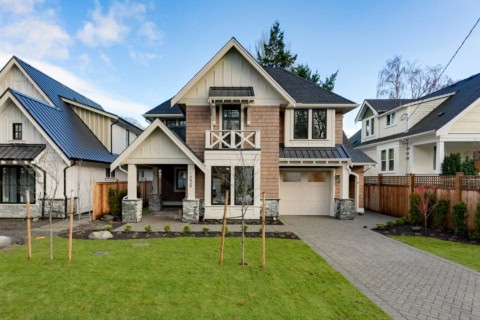 Exterior of a modern custom home by White Wolf Homes in Victoria BC with front lawn, walkway, and a.