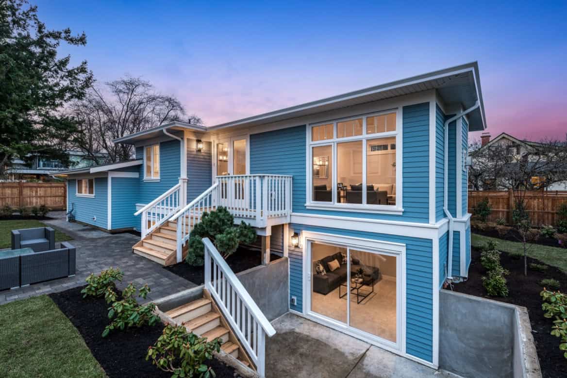Blue modern two-story custom home in Victoria BC by White Wolf Homes with blue siding and large bay窗.