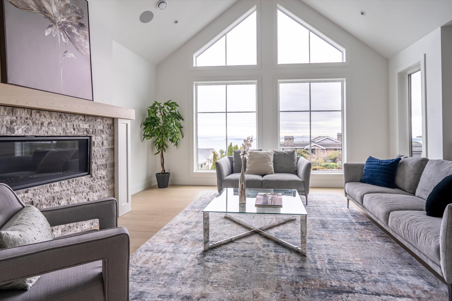 Modern living room with large vaulted windows and coastal views in Victoria BC.