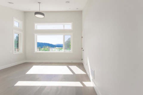 Bright empty living room with large windows and natural light.