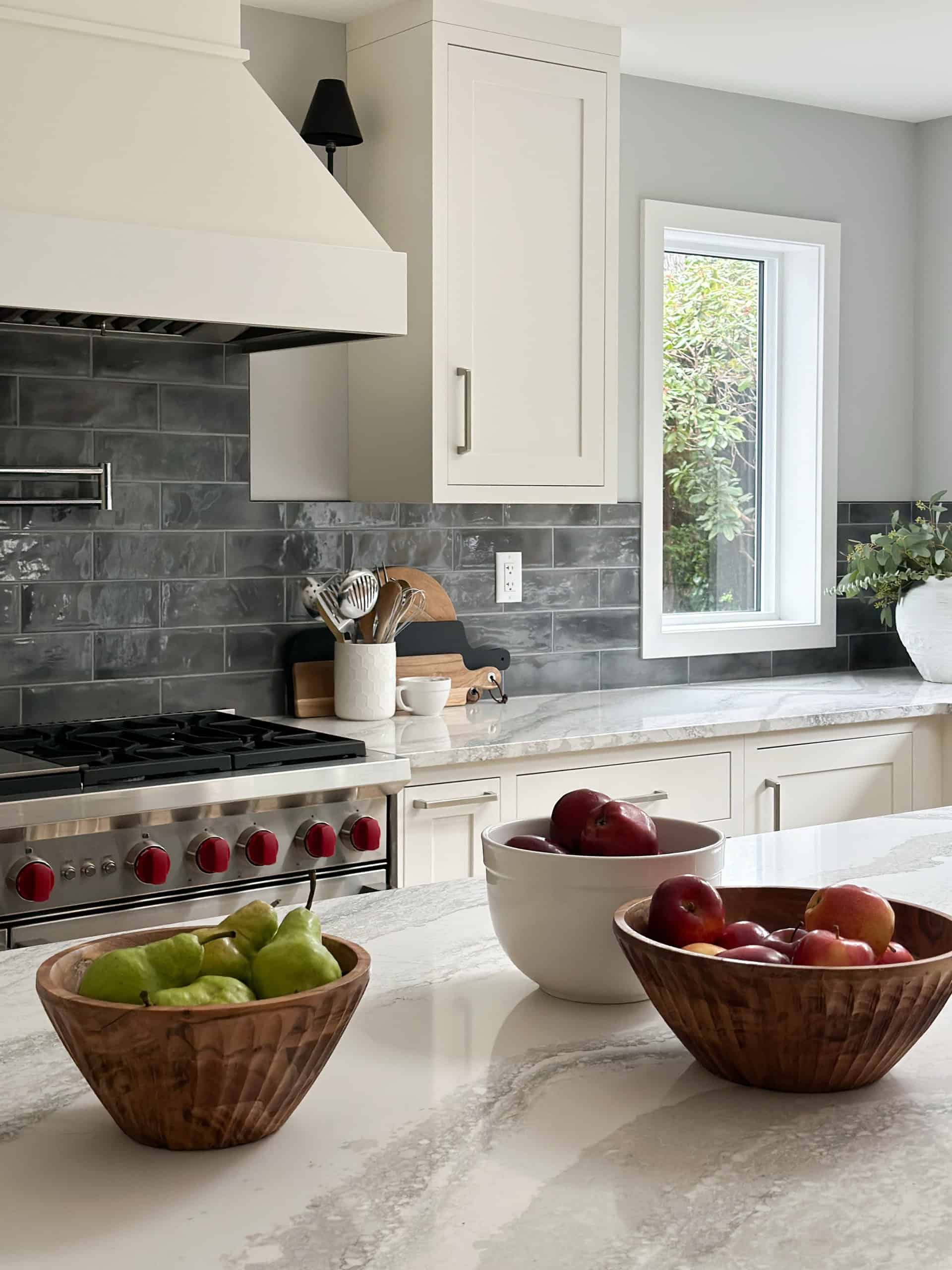 Modern white kitchen with marble island and gray subway backsplash in Victoria BC home.