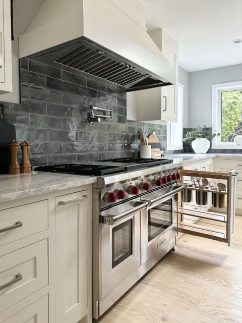 Modern kitchen with stainless steel range and white cabinets in a Victoria BC home.