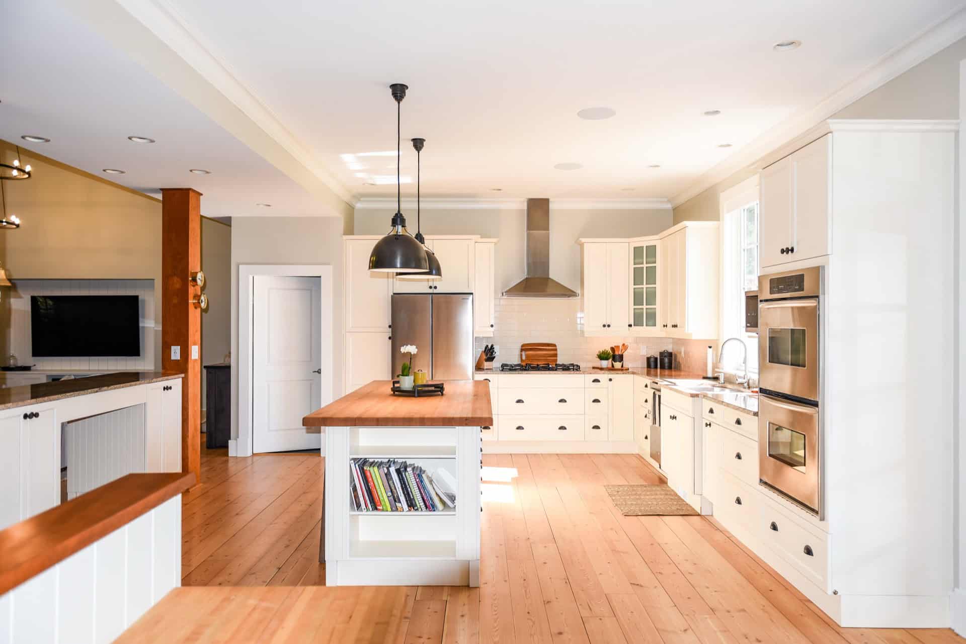Bright modern kitchen with white cabinets and wooden accents.