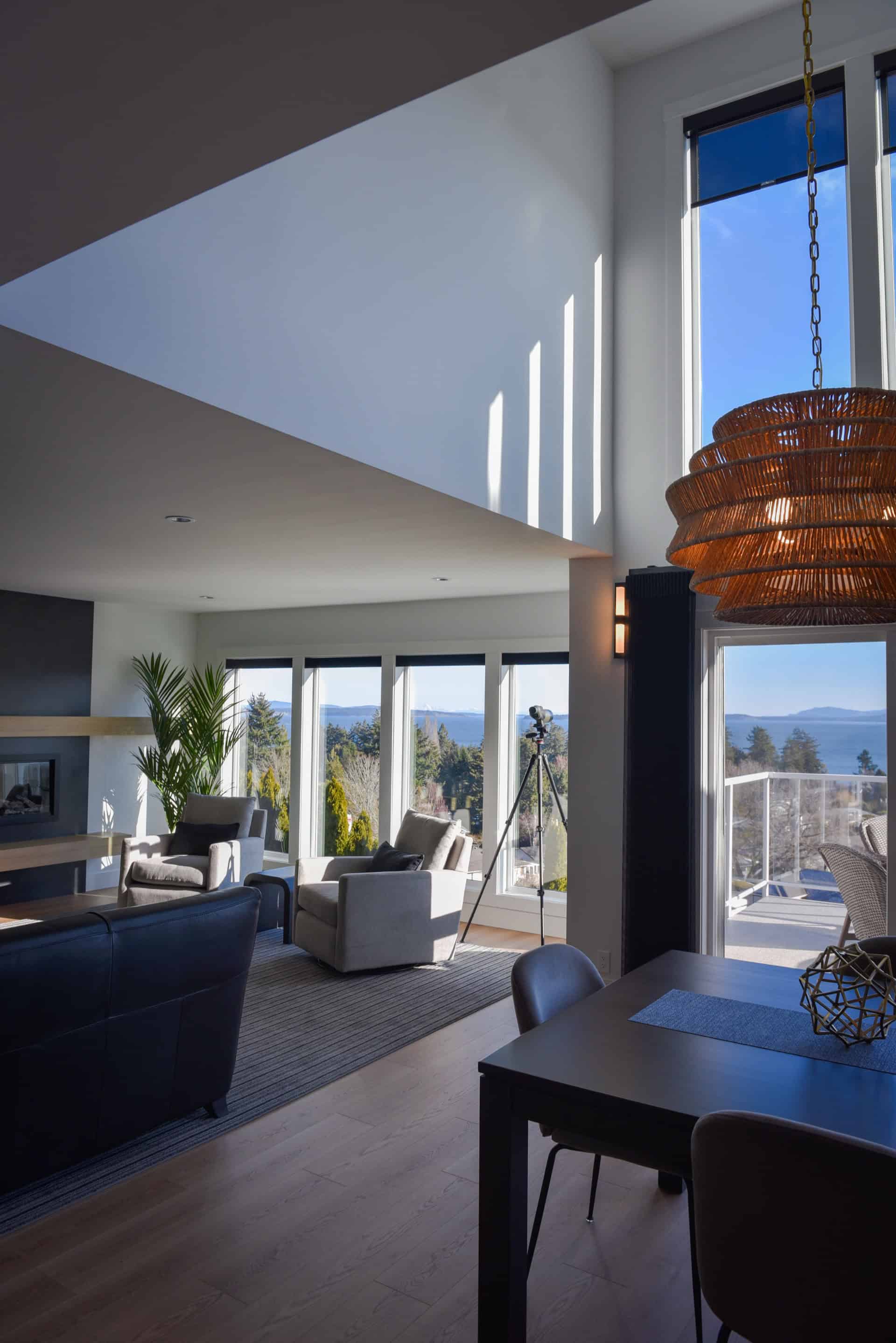 Bright modern living room with large windows and balcony views, open dining area.