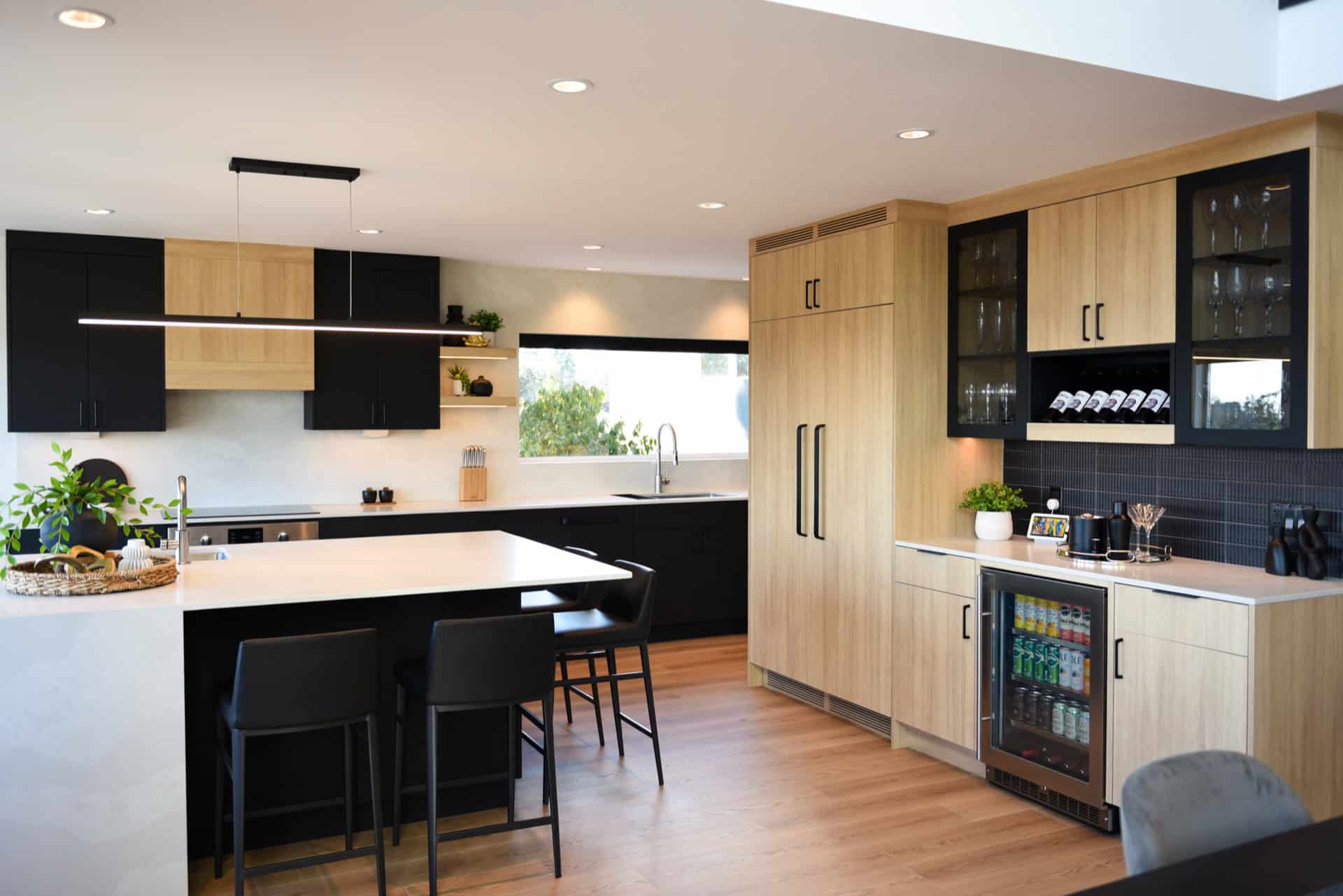 Modern kitchen with black and wood cabinets and island.