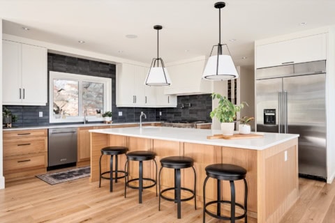 Modern white and wood kitchen with island and black bar stools in Victoria BC.
