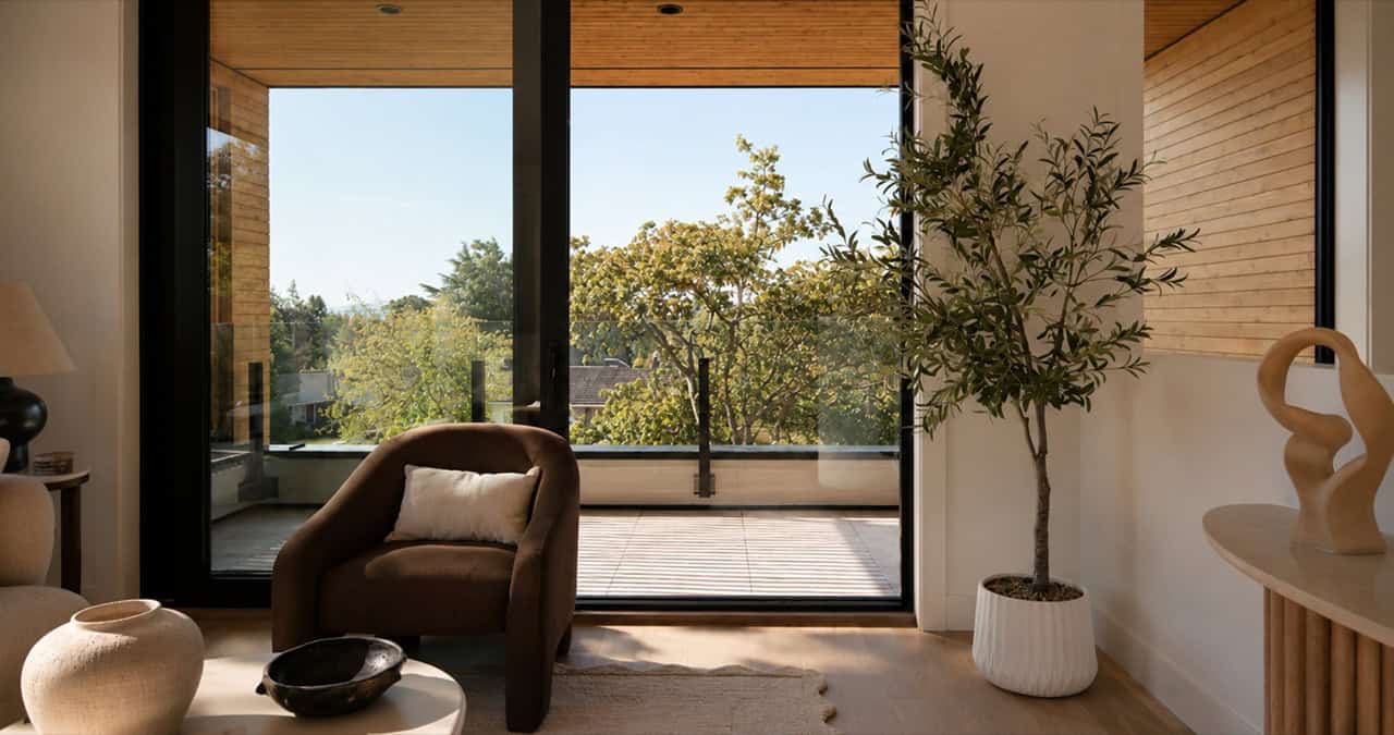 Interior living area with large windows and natural light featuring a plant and seating.